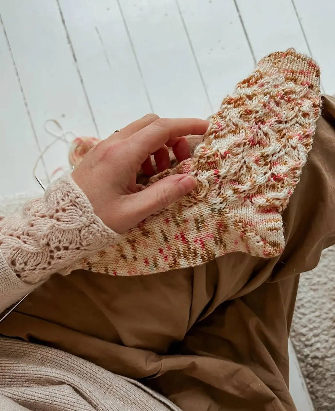 Sakura strømperne af Dorte Bak strikket i håandfarvet garn der ligger i skødet